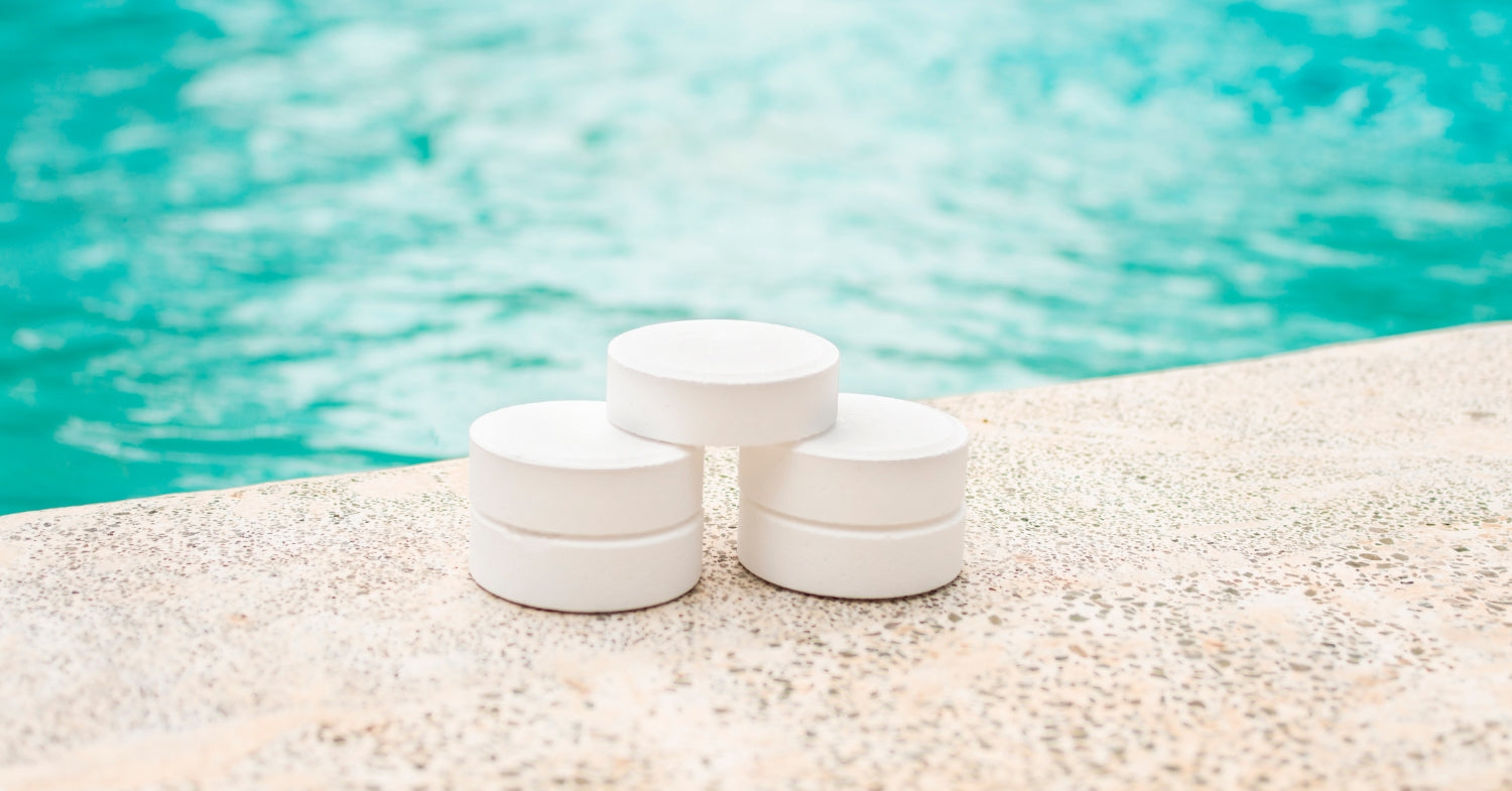 three chlorine tablets sitting on the edge of a swimming pool